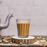 Indian chai in glass cups with metal kettle and other masalas