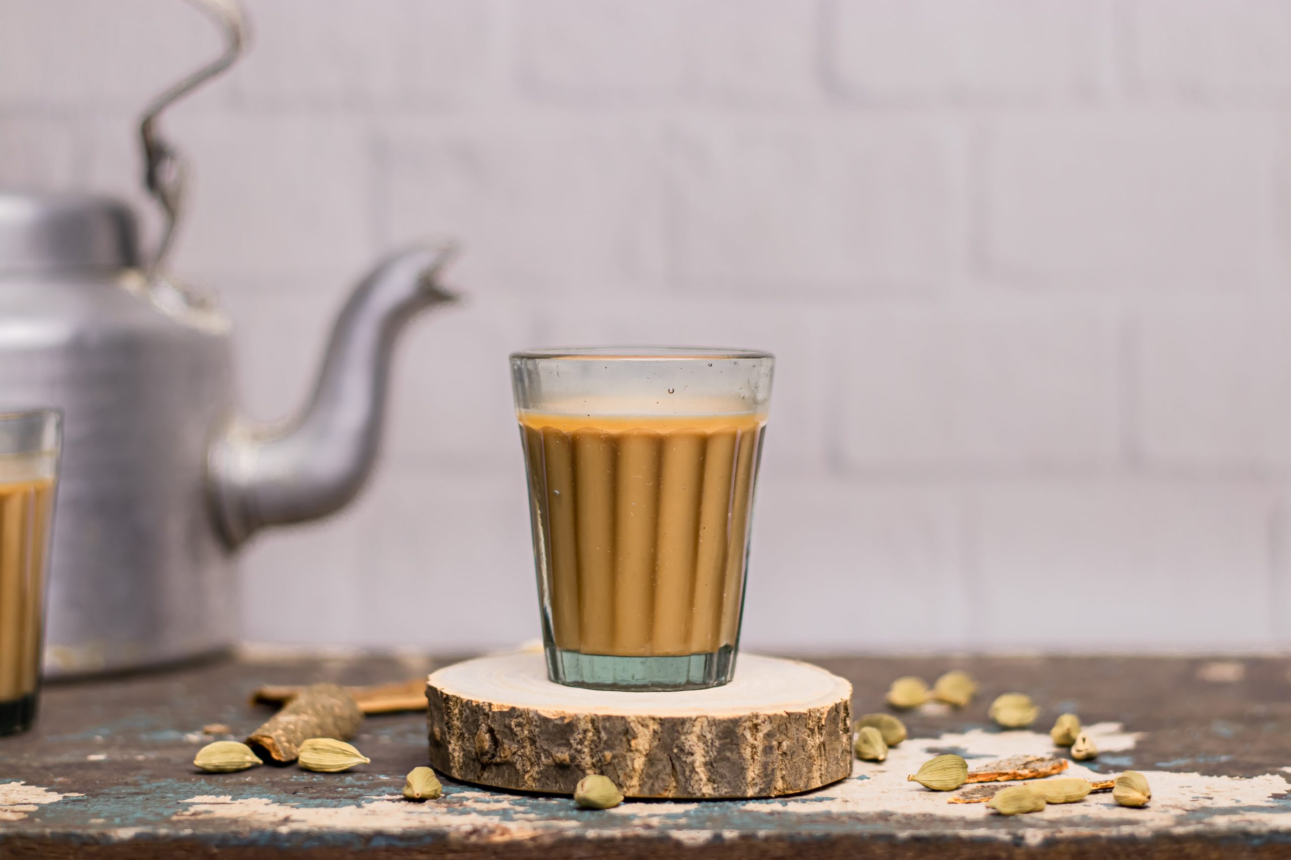 Indian chai in glass cups with metal kettle and other masalas