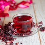 Red Hot Hibiscus tea in a glass mug on a wooden