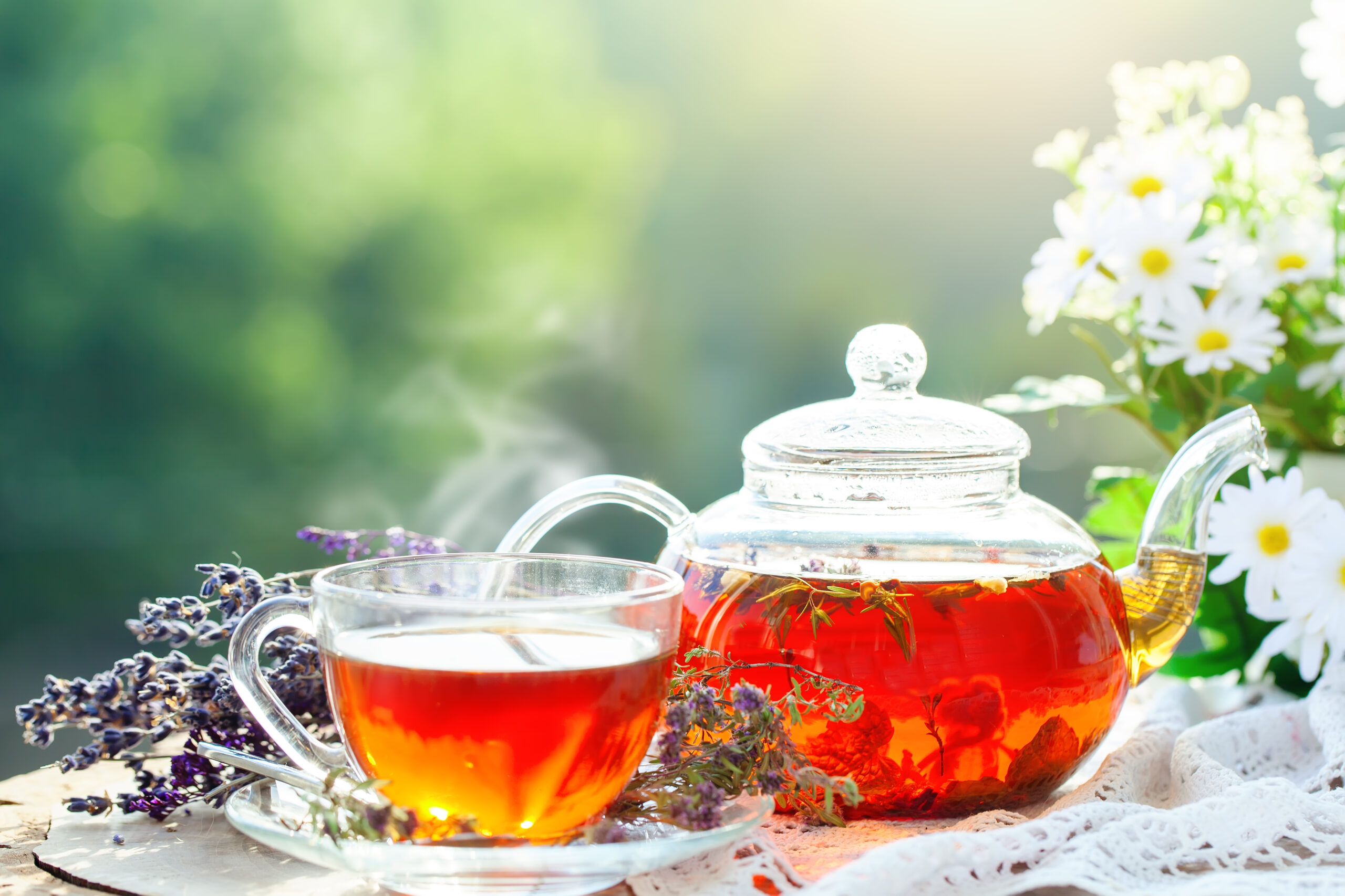 Cup with hot darjeeling tea with mint and a thyme on a wooden table