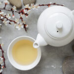 White Tea in a cup with white teapot